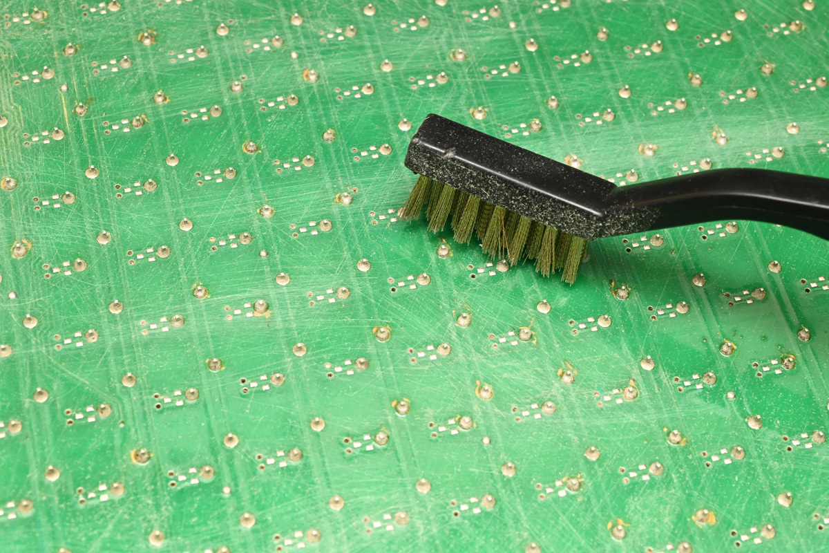 Brass wire brush scrubbing the back of a panel
