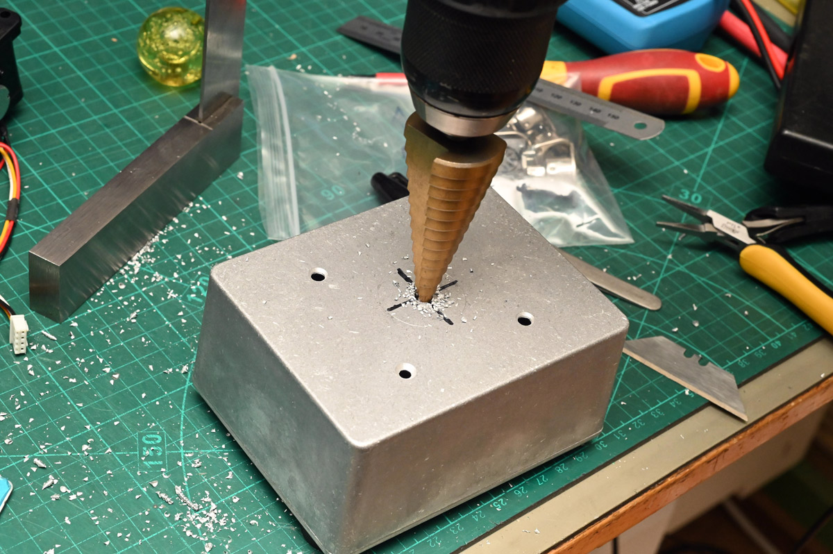 Using a step drill to make the hole pattern in the enclosure of the joystick