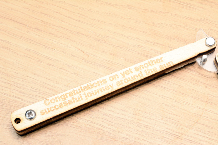 Laser etched text on the handle reads: Congratulations on yet another successful journey around the sun