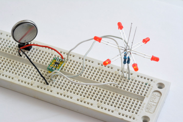 Through-mount LED circuit, running on a breadboard, with coin cell for power