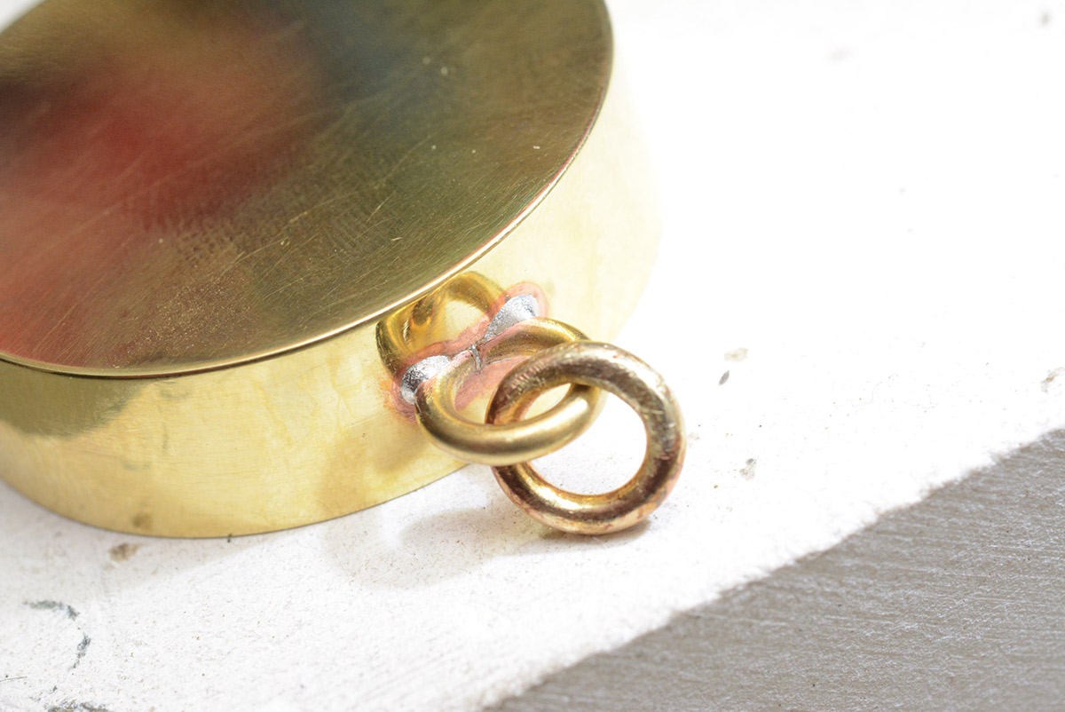 Closeup of tarnished brass around jump ring