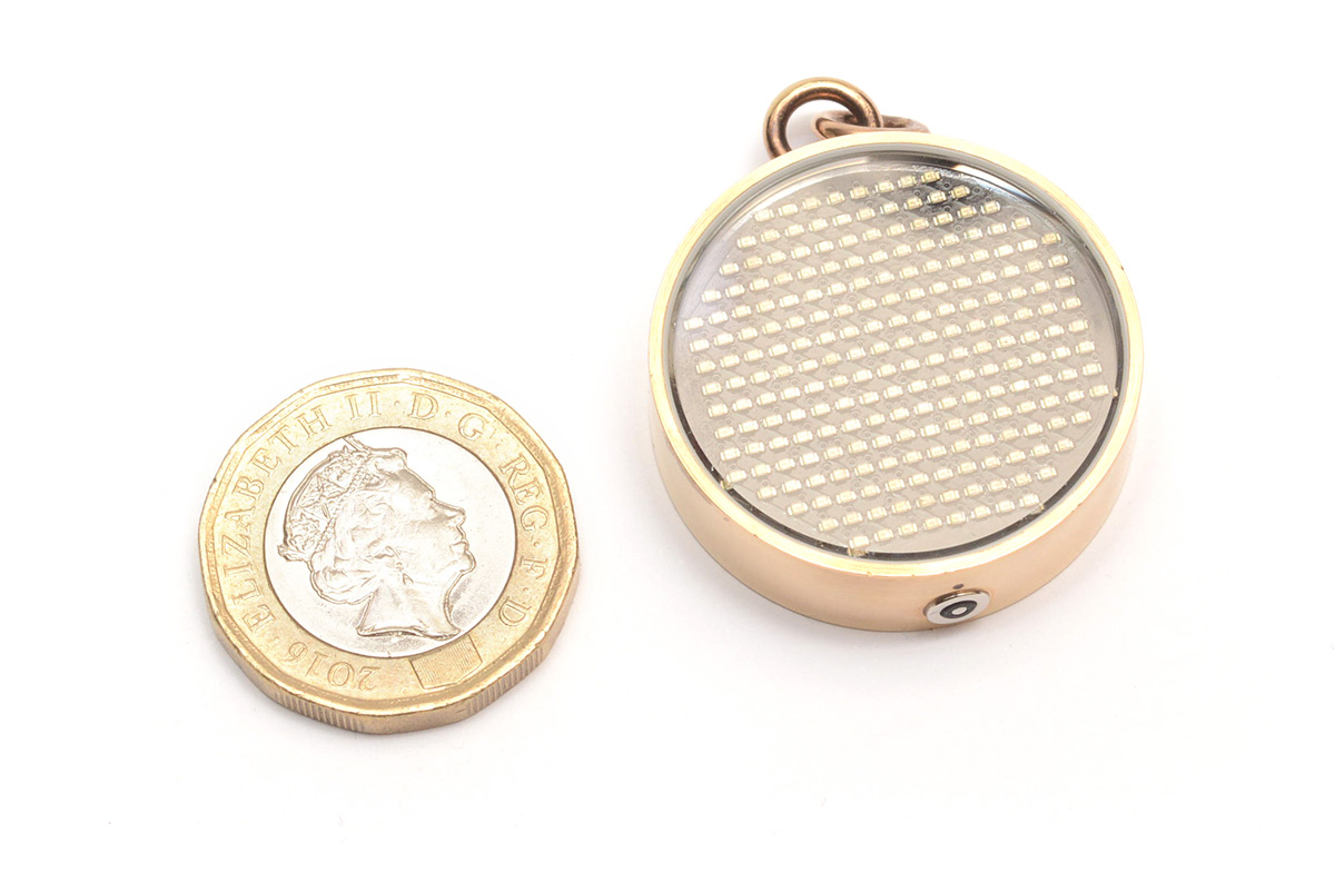 Pendant next to a £1 coin