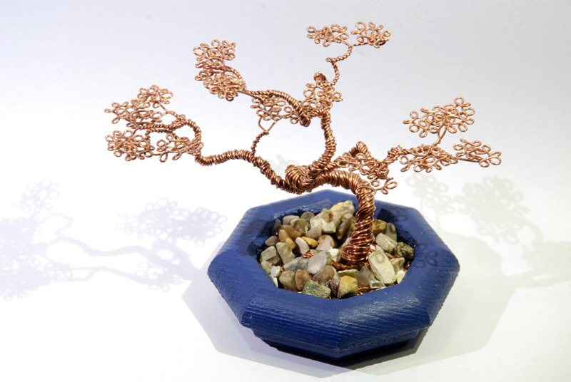 The metal bonsai showing the roots through the gravel