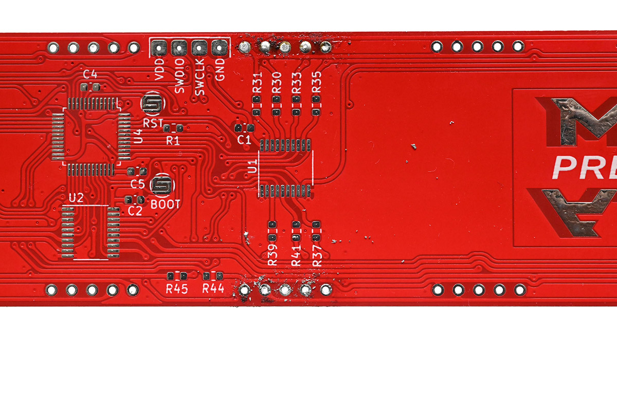 Holding the circuit up to the light, the bottom five pins have been cleared of solder