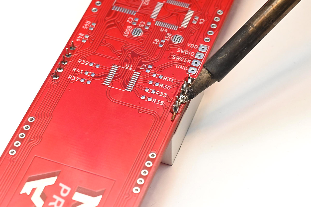 Flooding the wire, making sure each pin is wetted with solder