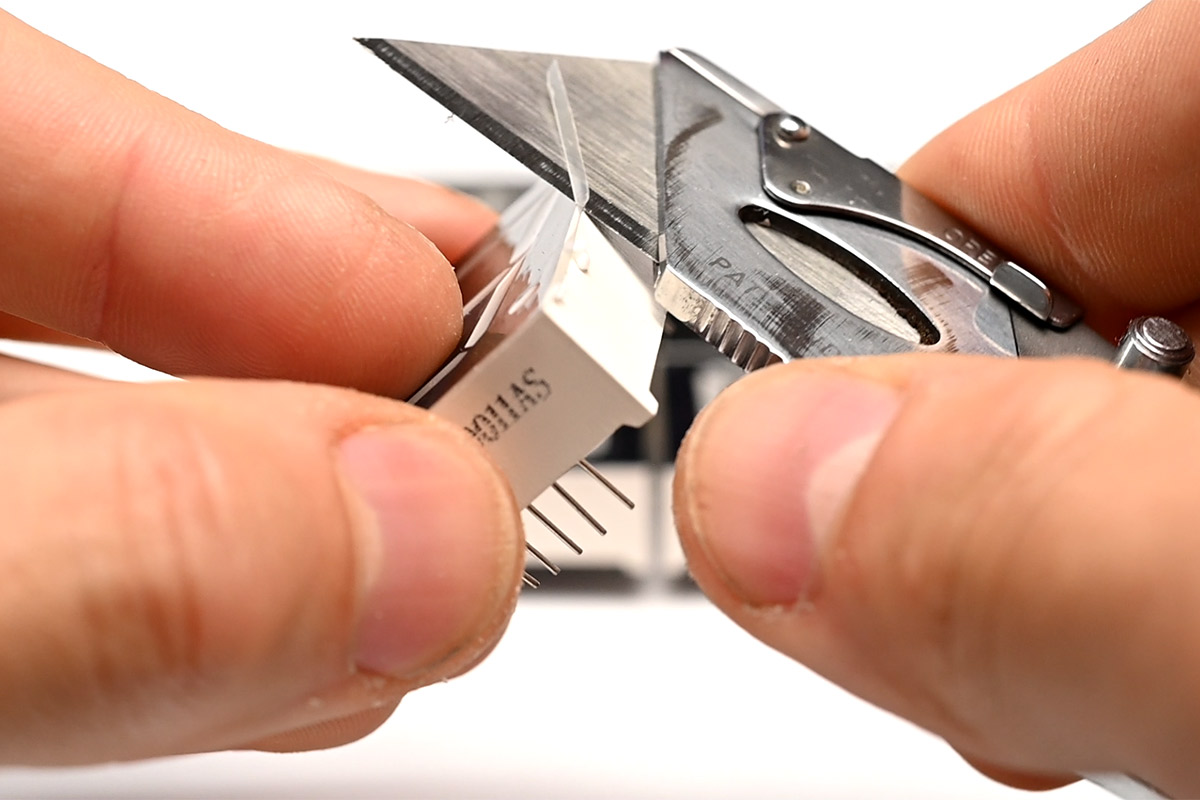 Run a sharp knife along the edge of the digit to trim the plastic film