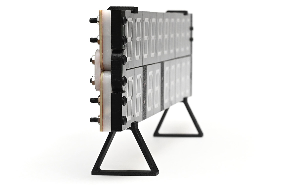 Edge view of clock in folded position held up by 3D printed stands