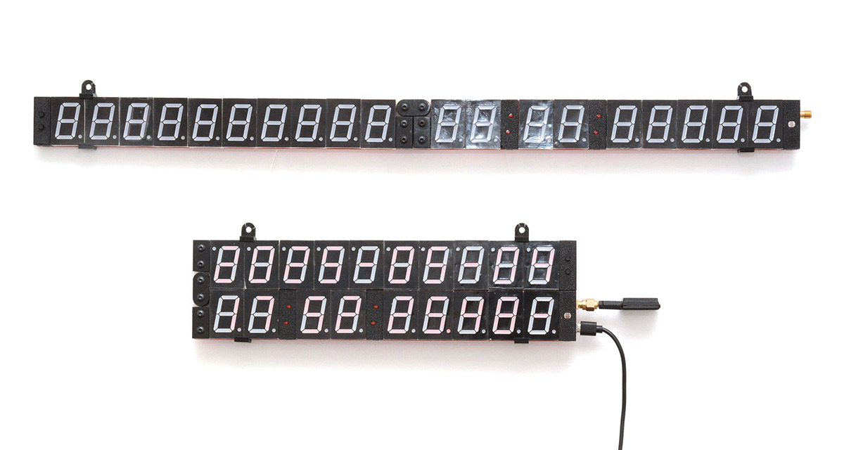 Two clocks, one in the folded position, hanging on a wall