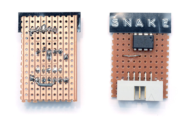Closeup view of the Snake cartridge, made from an EEPROM chip, header pins, protoboard and an embossed label