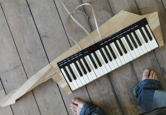 The keytar with keyboard and control panel, on the floor, with the author's bare feet visible