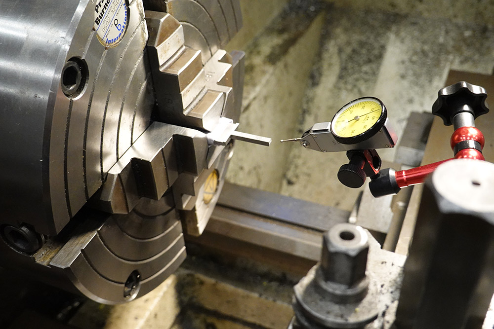 Using a dial test indicator to centre the rough-cut sword handle in the 4 jaw chuck