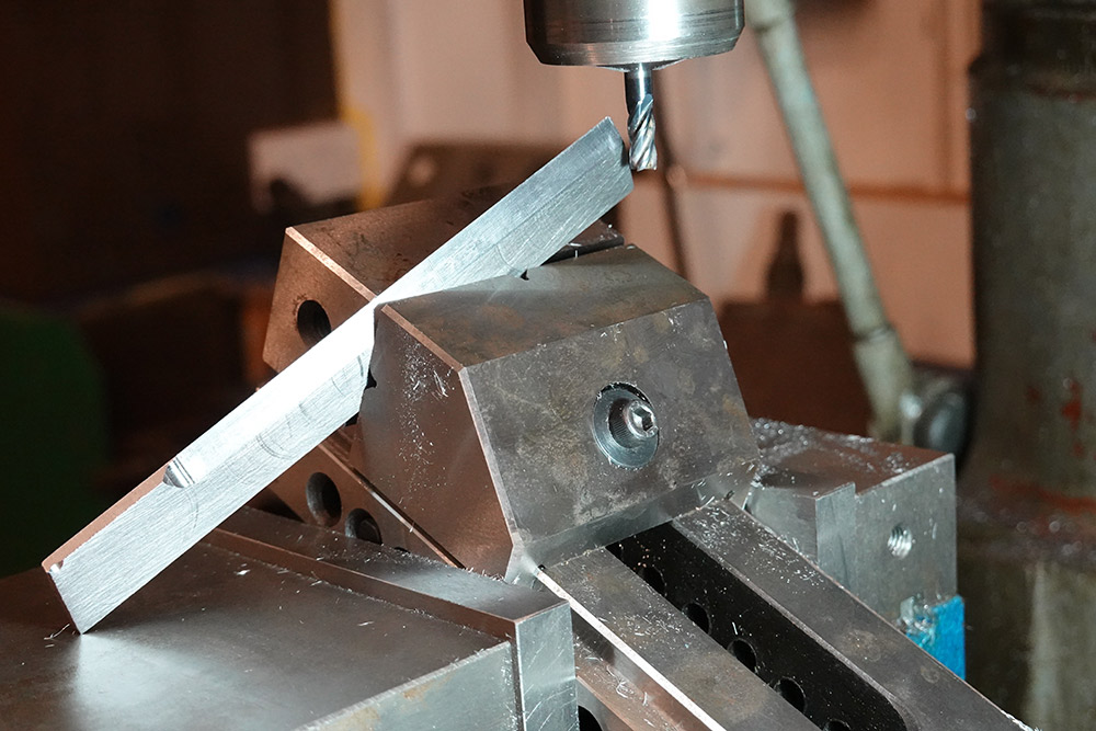 The part at an angle, held in a vice at another angle, held in the milling vice, which is turned at an angle