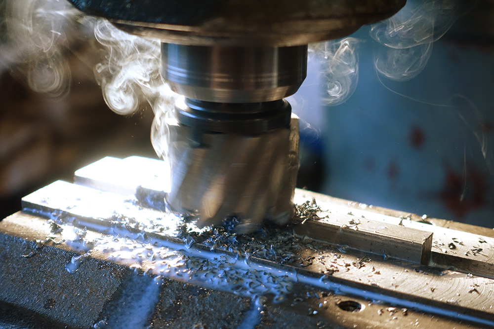 Large milling cutter plowing through material with coolant evaporating