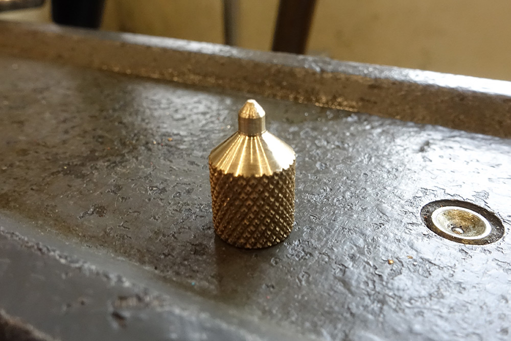 The brass bell shape before flatening and cross drilling