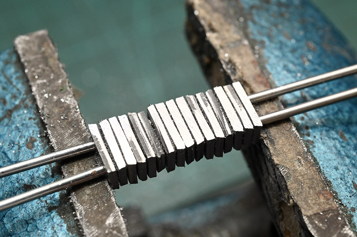 Stack of linkages in a vice, some filing has taken place