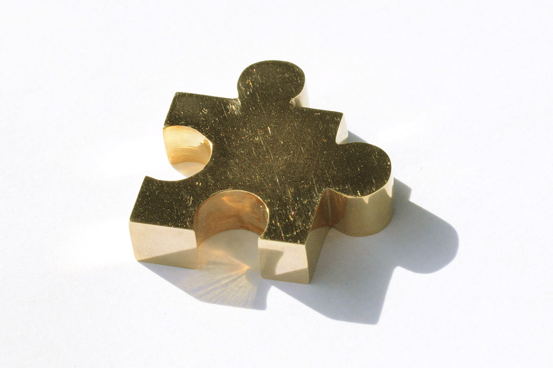 Finished golden jigsaw piece lying on its back
