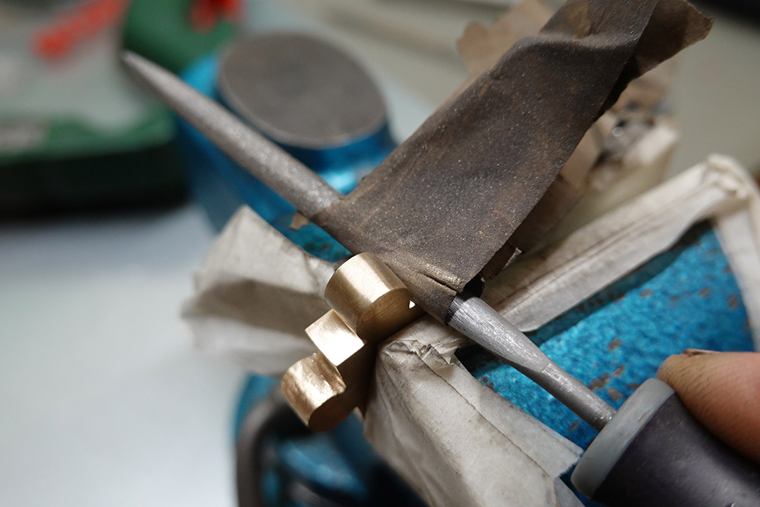 Using a needle file to work the sandpaper