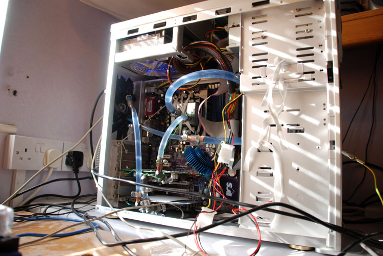 Sunlight and window blind shadows over the watercooled setup with fluid pumping through it