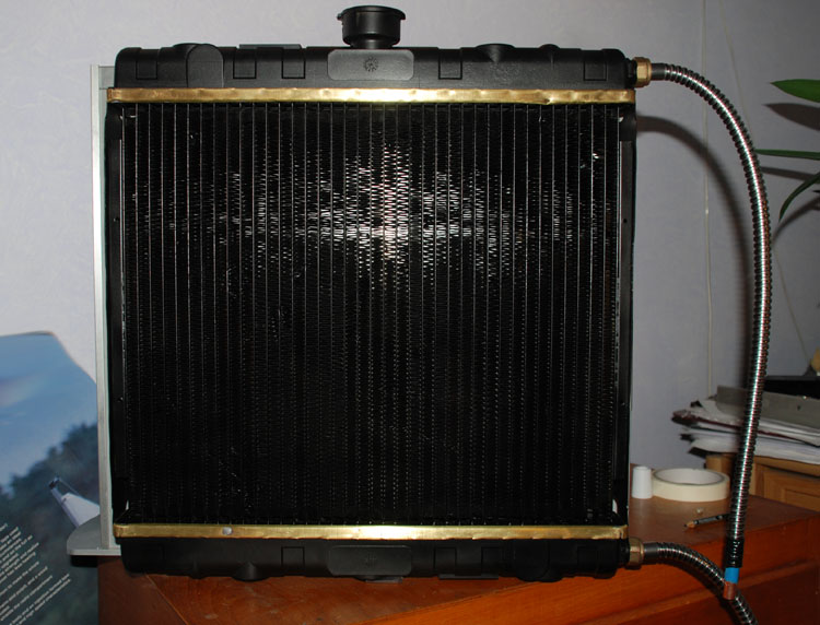 The radiator with brass sections exposed and dangling hoses