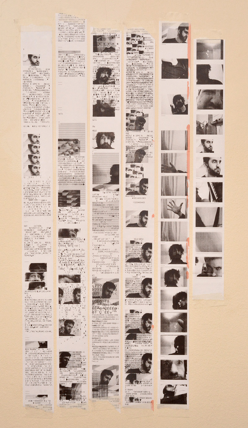 The ribbons of thermal paper, featuring hilarious misprints and glitches, mounted on the wall.