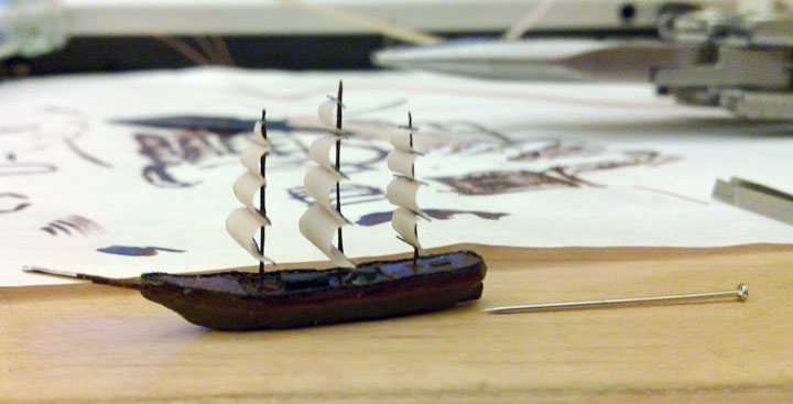 Partly assembled ship next to a dressmaker's pin