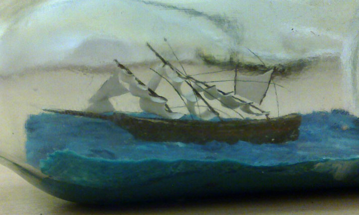 Ship in bottle damaged with masts bent forwards