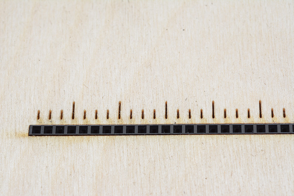 Macro shot of female header pins in plywood frame