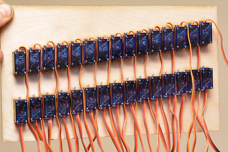 Underside of the thirty servos mounted in plywood